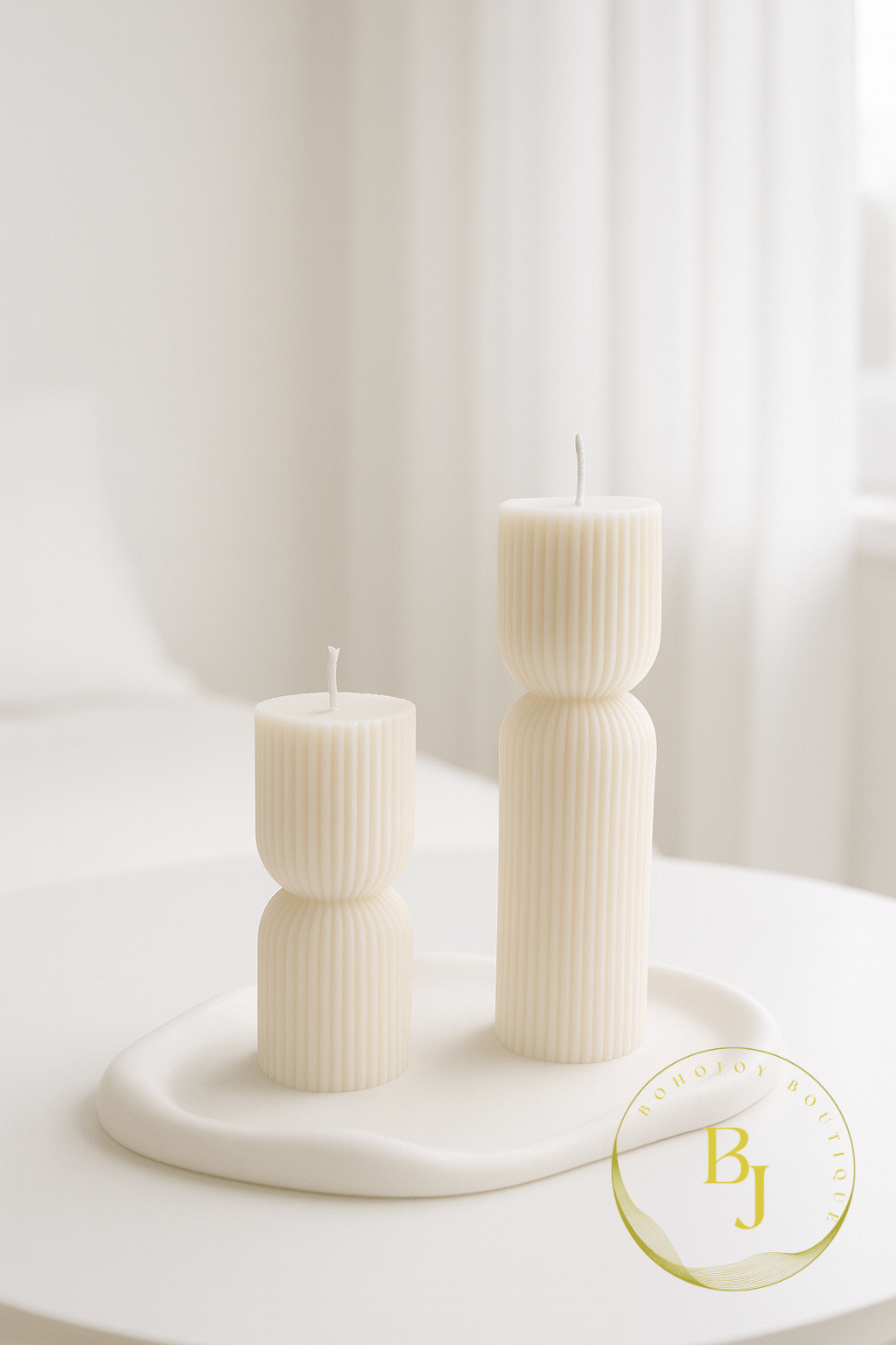 Bougies DUO GALET sculpturales cannelées, design minimaliste sur une table élégante.