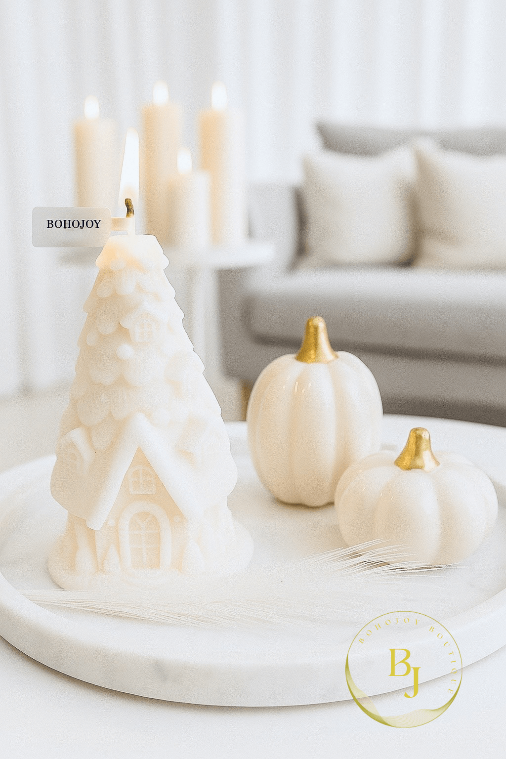 Bougie en forme de maisonnette enneigée sur une table, ambiance cocooning pour Noël.