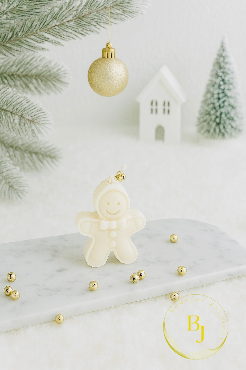 Bougie Le Petit Blanc d’Hiver en forme de bonhomme pain d’épice sur un plateau décoratif.